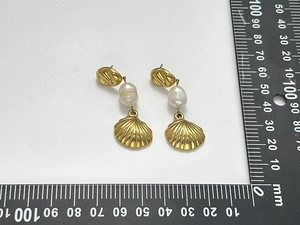 Macro detail of 45mm gold shell earrings with pearl inlay and stainless steel texture