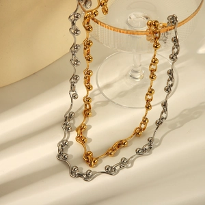 Detailed view of geometric wavy stainless steel necklace in gold and silver finishes