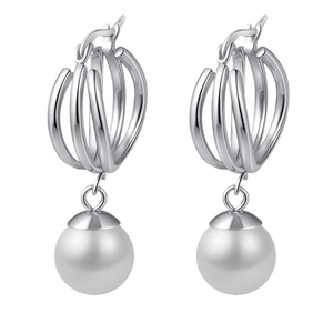 Boucles d'oreilles triple anneaux argentés avec un pendentif perle blanche sur fond blanc