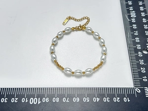Détail du bracelet en perles avec poinçon S.STEEL et échelle de mesure précise