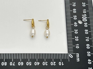Détail des boucles d'oreilles perles dorées 18K avec échelle mesurant 25 mm
