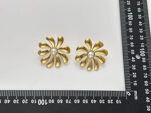 Detail shot of 30mm gold flower earrings with white pearls next to a size scale