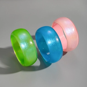 Macro shot of three chunky pearlescent resin bangles in green, blue, and pink colors
