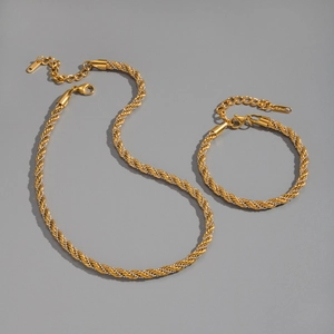 Détail d'un ensemble de bijoux chaîne torsadée bicolore en acier doré à l'or 18 carats