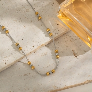 Collana minimalista con perline bicolore oro e argento su base in pietra naturale
