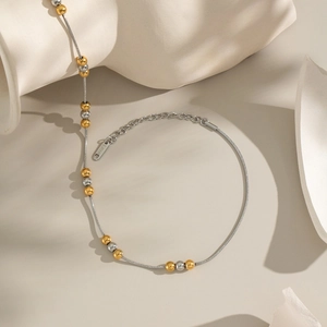 Dettaglio della collana catena serpente in acciaio bicolore con perle oro e argento