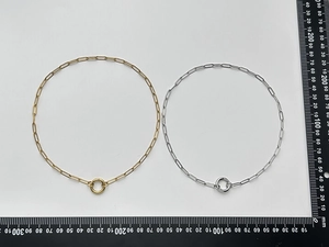 Detail view of gold and silver paperclip link necklaces with circular spring clasps