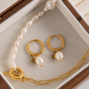 Close-up of freshwater pearl earrings and necklace set with star charms in a jewelry box