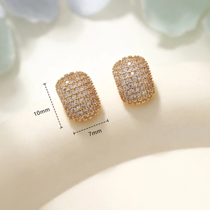 Macro shot of gold geometric earrings with pavé crystals measuring 10mm by 7mm