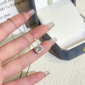 Macro detail of silver square halo pendant necklace with central round crystal stone