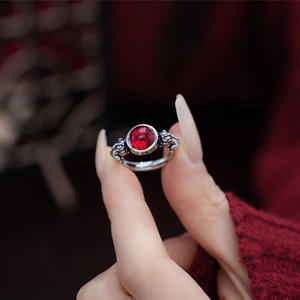 Detailed shot of retro silver ring with red gemstone and ornate lion carvings