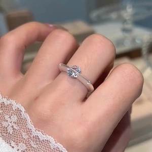 Macro shot of silver-colored star ring with sparkling cubic zirconia on a female finger