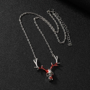 Detail of silver skull pendant with red antlers on dark textured background