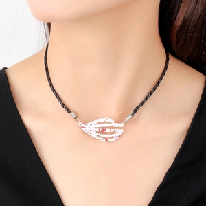 Detail of gothic skeletal hand necklace with red blood splatters and black woven cord