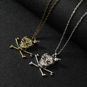 Detailed view of punk style bronze and silver skull pendants with snake eye details