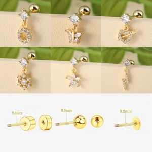 Detalle de piercings de oreja dorados con circonitas y cierres de rosca de 0,8 mm de grosor