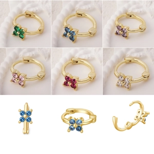 Detalle de pendientes huggie de flores con circonitas de colores en seis acabados metálicos