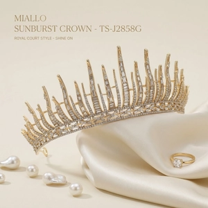 Luxury gold sunburst bridal crown with clear crystals on silk fabric background