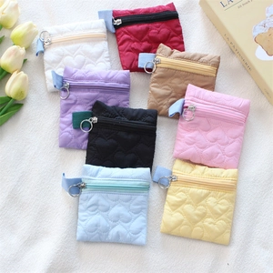 Variety of colorful heart quilted coin purses with zipper closures in a lifestyle setting