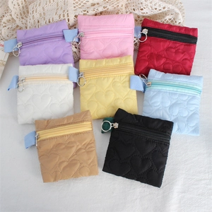 Detailed flat lay of eight colorful heart-quilted coin purses with metal zippers and loops