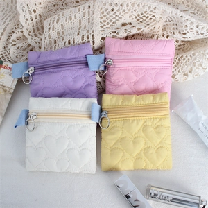 Detailed view of quilted heart coin purses in four pastel colors with metal ring zippers