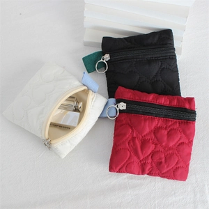 Quilted heart zip coin purse in black, red, and white on a textured linen background