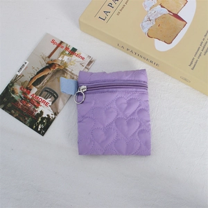 Detail of purple quilted heart pattern coin purse with zipper and side handle strap