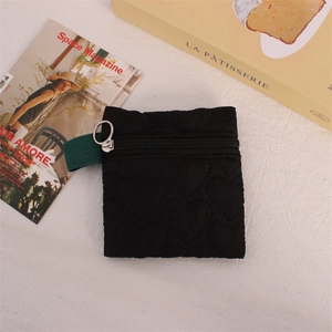 Detailed view of black quilted heart pattern coin purse with metal ring zipper and nylon fabric
