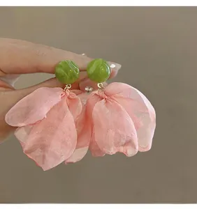 Detail of French vintage earrings with green marble studs and pink chiffon fabric petals