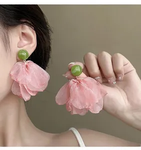 Close-up of French vintage chiffon flower earrings with pink organza petals and green beads