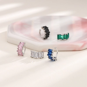 Macro detail of rectangular colorful zircon ear cuffs in black green and pink stones