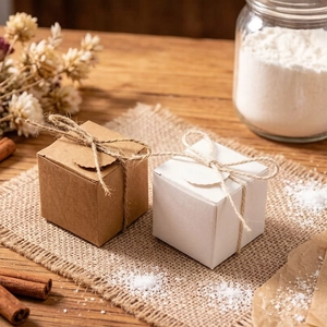 Detail of square kraft and white paper gift boxes with rustic twine and tags