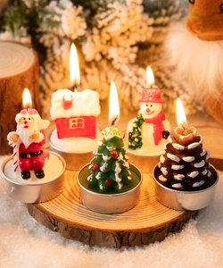 Detailed view of burning Santa, snowman, and pine cone tea light candles on wood