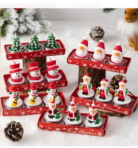 Detailed view of Santa and snowman tea light candles on snowy wood for Christmas decor