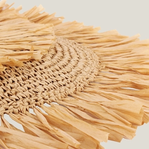 Bohemian style woven straw bag with tassels and spiral pattern for beach vacations