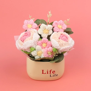 Handmade crochet rose potted plant with pink and white flowers on a pink background