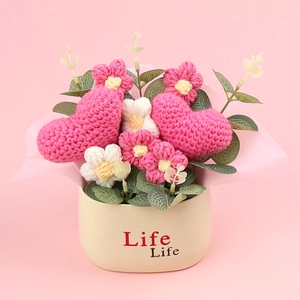 Handmade crochet flower pot with pink hearts and white daisies on a soft pink background