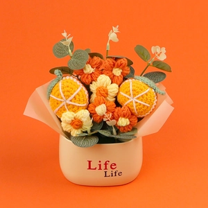 Detail of handcrafted crochet sunflower and citrus potted plant on vibrant orange background