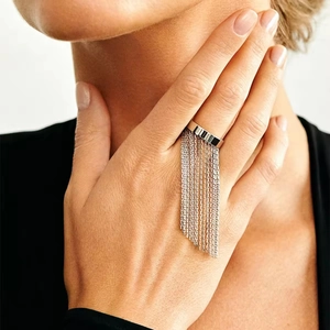 Detail of silver chain tassel ring on finger showing polished finish and fringe design