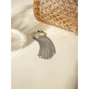 Detailed shot of a silver tassel ring with fine bead chains against an artistic background
