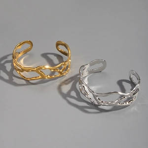 Detailed view of hollow irregular gold and silver bangles with liquid metal aesthetic