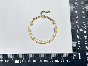 Flat snake chain and pearl double-layer golden bracelet showing size measurement detail