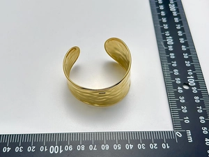 Close-up of golden wide hammered cuff bracelet with ruler showing 40mm width scale