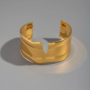 Macro detail of 18K gold plated wide cuff bracelet featuring unique irregular wave edges