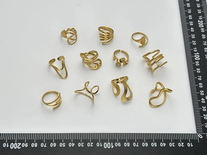 Vue à plat de 10 bagues minimalistes en acier inoxydable doré avec échelle de mesure