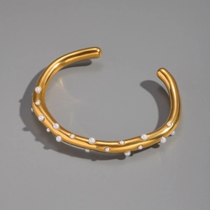 Detailed macro view of 18K gold plated bangle with integrated shell pearls