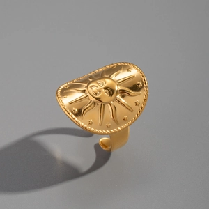 Macro detail of sun face relief and starburst pattern on gold plated stainless steel ring