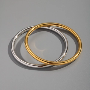 Close-up of minimalist gold and silver polished stainless steel bangles set