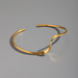 Detailed close-up of a minimalist golden wavy open collar necklace with polished finish