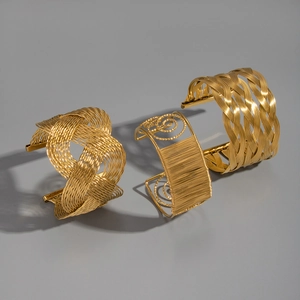Detailed view of three gold mesh woven cuff bracelets with intricate wire patterns
